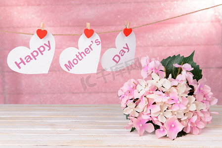 幸福的母亲一天消息写在纸做的爱心与粉红的底色上的花朵