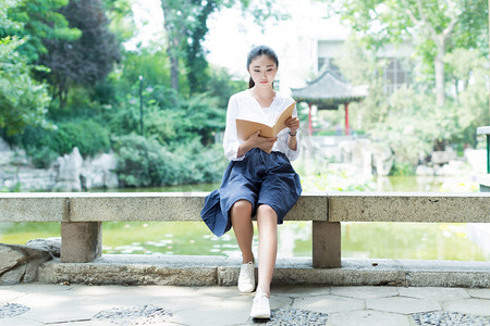 休假日摄影照片_在公园里读书的女孩
