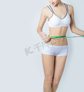 年轻体育美丽苗条的女人测量完美的造型漂亮的臀部，在白色背景上健康的生活方式的概念