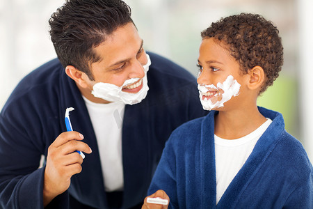 整洁的胡子摄影照片_俏皮的父亲和儿子在一起剃须