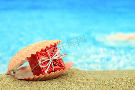 summer水纹摄影照片_Gift box in a sea shell on the beach