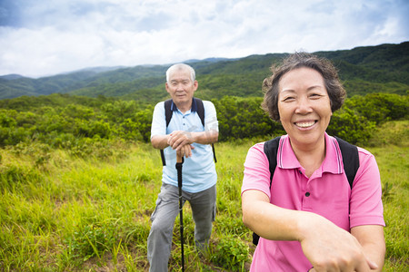 happy senior couple hiking on the mountain