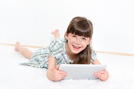使用電腦摄影照片_快乐的小女孩用平板电脑