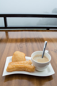 泰国炸的 doughstick 和木桌上的咖啡，早餐