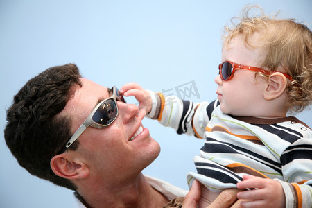 天空青春摄影照片_与戴太阳眼镜的天空背景下的孩子的父亲