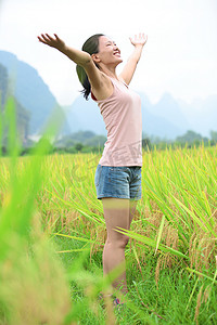 徽州农田摄影照片_年轻的亚洲女人张开双臂在水田