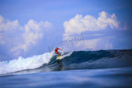 巴里島摄影照片_令人惊异的蓝色波浪的冲浪者