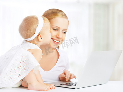 妈妈和宝宝在家里使用便携式计算机