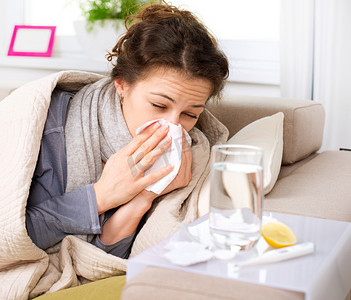 人物沙发摄影照片_流感或感冒。打喷嚏女人病吹鼻子