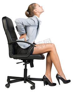 女商人从坐在办公椅上的下背部疼痛