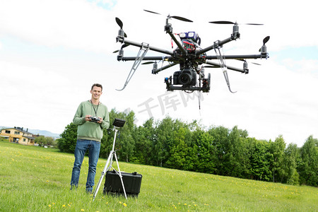 飞机里摄影照片_飞行无人机 octocopter 在公园里的技术员