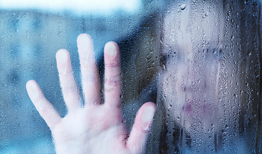 1孤独摄影照片_忧郁和悲伤的年轻女子在雨中的窗口