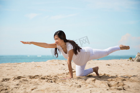 瑜伽大海摄影照片_亚洲孕妇做瑜伽在大海的岸边