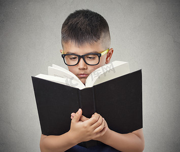 阅读坚持摄影照片_戴着眼镜看书的孩子