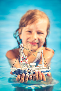 孩子抱着玩具帆船