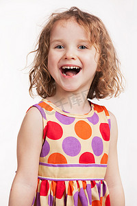 小女孩发型摄影照片_快乐的小女孩，在一件鲜艳的衣服