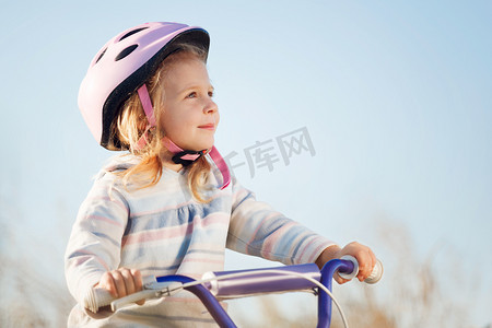 有趣的小孩子骑自行车用训练轮子.