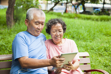 快乐老人夫妇与 tablet pc 在公园