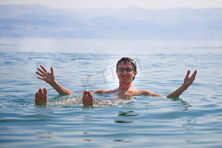 一个人在于他的手上在以色列死海的水