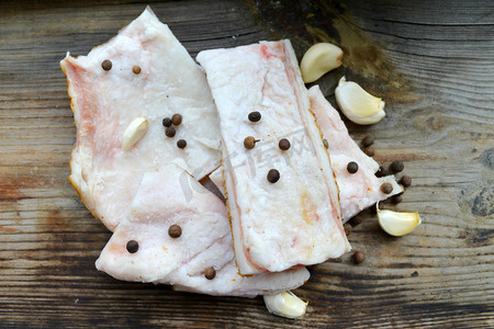 美味印章摄影照片_白猪肉脂肪，在木制的厨房桌子上叫做隽永的蒜和胡椒