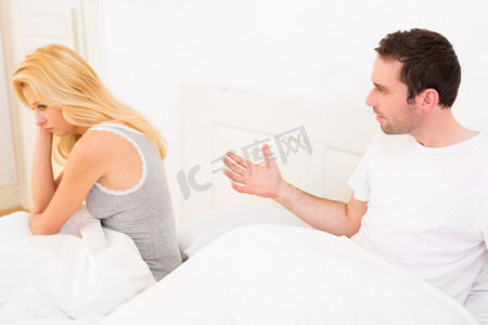 年轻有吸引力对夫妇争论在床上