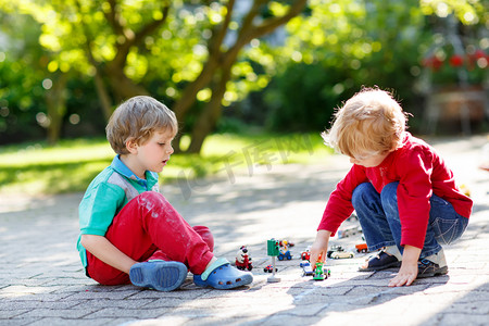 Two little kid boys playing with car toys