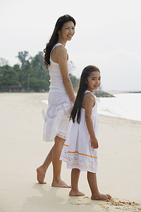 母亲和女儿站在海滩上