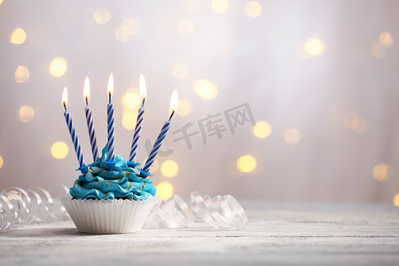 巧克力粉摄影照片_在明亮的背景上的桌上美味的生日蛋糕