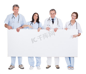 白色高级海报背景摄影照片_组的医生抱着标语牌