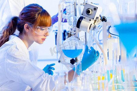 高考蓝色背景摄影照片_年轻的化学家在实验室.