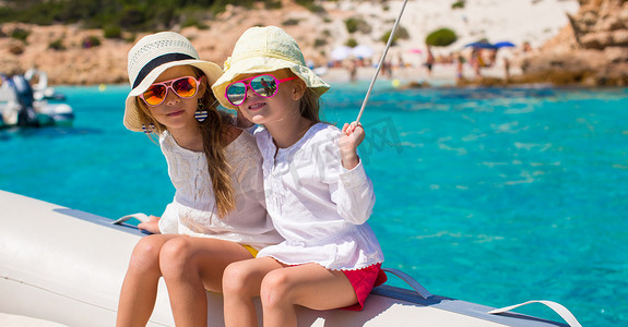 快乐之旅摄影照片_可爱的小女孩们喜欢在大海中乘船航行