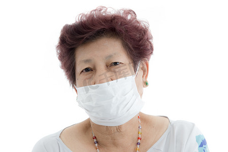 病毒蔓延摄影照片_亚洲高级妇女参与保护医疗面罩上白色.