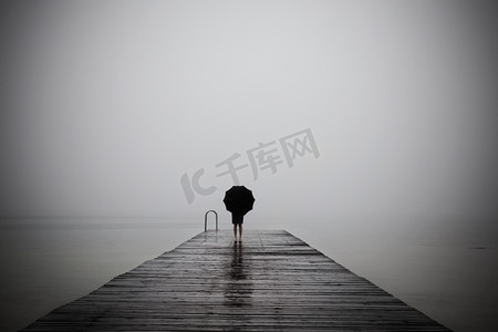 忧郁摄影照片_优雅的女人穿着黑色隐藏用的伞