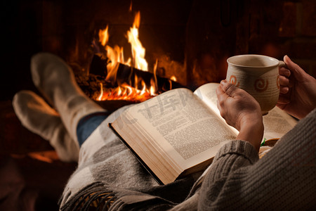 女人读本书靠近壁炉旁