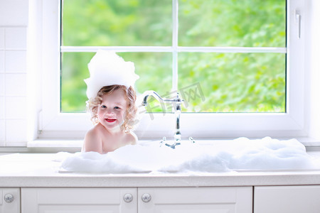 宝宝浴室摄影照片_Baby girl taking bath with foam