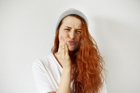 woman pressing cheek with painful expressio