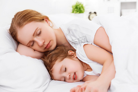 快乐家庭的母亲和孩子睡在床上