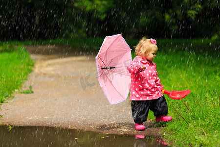 可爱的小女孩，用雨伞雨衣和雨鞋