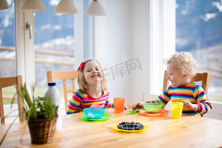 孩子们在阳光明媚的厨房里吃早饭