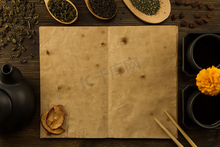 菜单二折页摄影照片_黑茶壶, 两杯, 茶收藏, 鲜花, 木制背景上的旧空白打开书。菜单, 食谱, 模拟