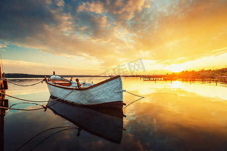 平静的湖面和反映我的天空一只小船美丽的日落