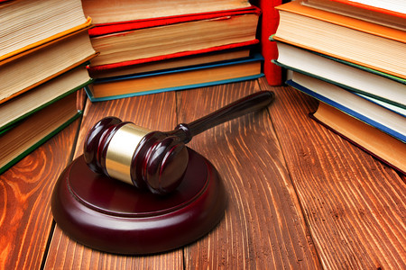 法律书籍与木槌木法官在法庭或法律的执法办公室的桌子上.
