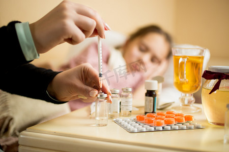 Macro shot of woman filling syringe from ampule