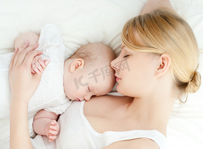 年轻的母亲和她的孩子睡在床上