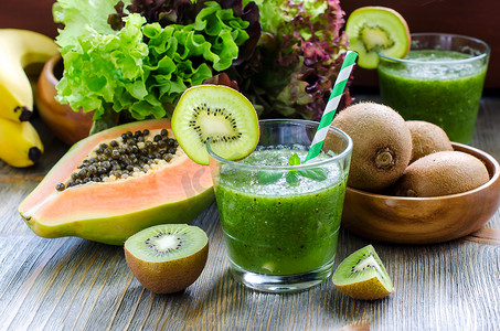 Green tropical smoothie with kiwi, papaya and salad leaves