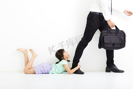 哭吧摄影照片_小女孩抱着她父亲的双腿前去上班