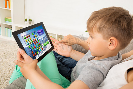 小孩在数字平板电脑上玩游戏