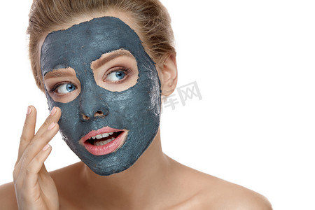 美容面部护理。女性与自然妆应用泥面膜