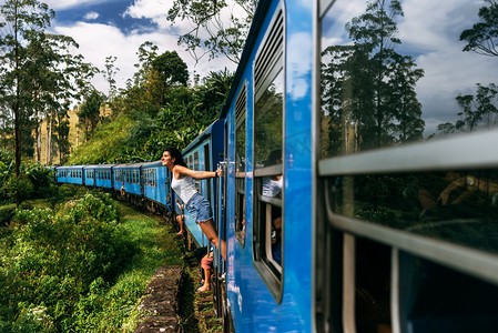这个女孩乘火车去美丽的地方。美丽的女孩乘火车在山间旅行。乘火车旅行。前往亚洲。火车斯里兰卡。铁路运输。铁路。亚洲运输公司