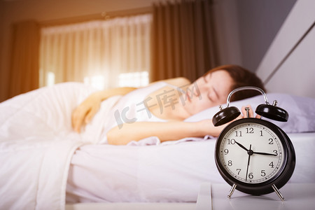 时钟显示 10 上午。和女人睡在床上与铁道部的阳光